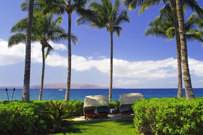 Sit under umbrella cabana-styled chairs in the warm weather breeze